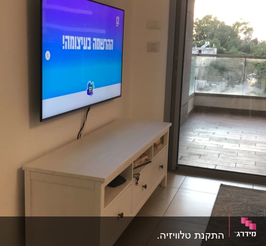 טלוויזיה תלויה על הקיר עם כבלים חשופים